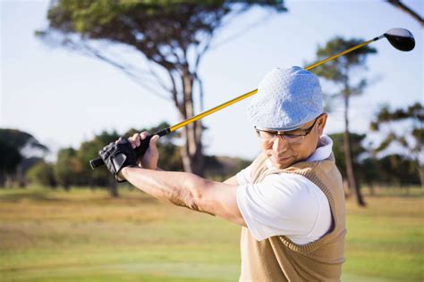 Un golfista che esegue uno swing con un bastone ibrido