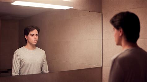 Persona che si guarda allo specchio distorcendo la propria immagine