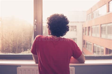 Persona che guarda fuori dalla finestra con un'espressione pensierosa