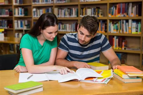 Studente che studia su manuali tecnici in una biblioteca