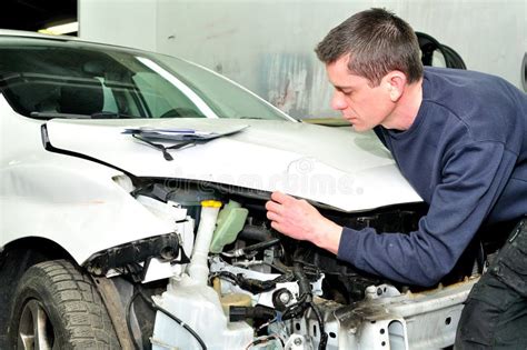 Meccanico che ispeziona il sottoscocca di un'auto sul ponte