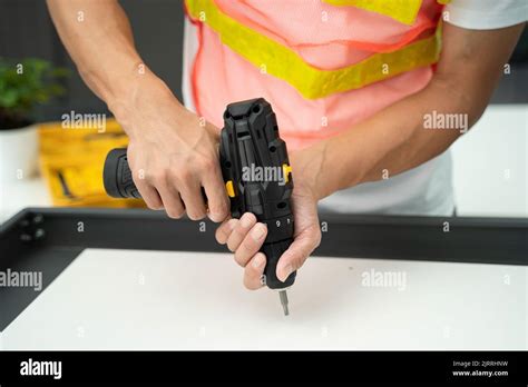 Illustrazione di una mano che usa un cacciavite piatto per fare leva su una clip di plastica