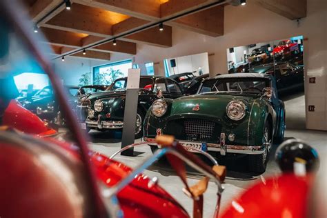 Un gruppo di collezionisti che mostra con orgoglio le proprie auto d'epoca durante un raduno