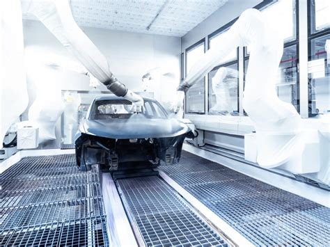 Robot in un reparto di verniciatura automobilistica con carrozzerie in movimento