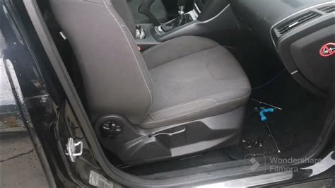 Interno di un'auto con focus sulla leva di sblocco del cofano