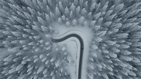 Vista aerea di un'auto che percorre una strada tortuosa in montagna