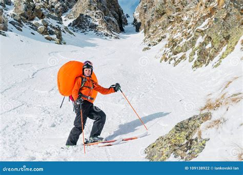 Sciatore con zaino airbag in ambiente montano innevato