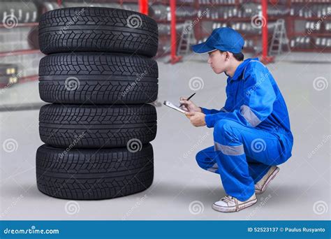 Meccanico che ispeziona il sottoscocca di un'auto sul sollevatore