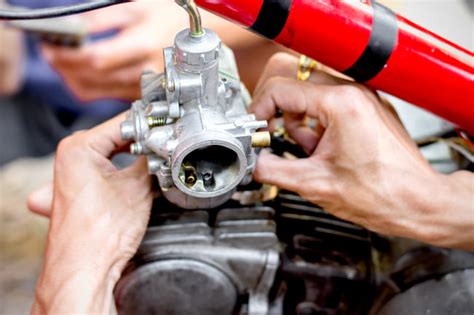 Meccanico che lavora su un carburatore di una moto