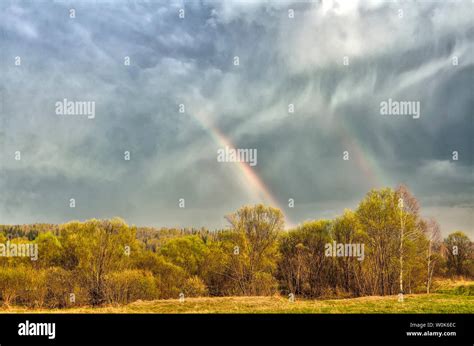 Paesaggio rurale dopo la pioggia, con un arcobaleno in lontananza