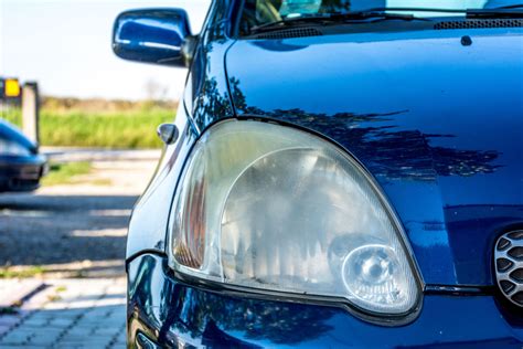 Immagine di un'auto con fari opacizzati e poi restaurati con vernice spray trasparente.