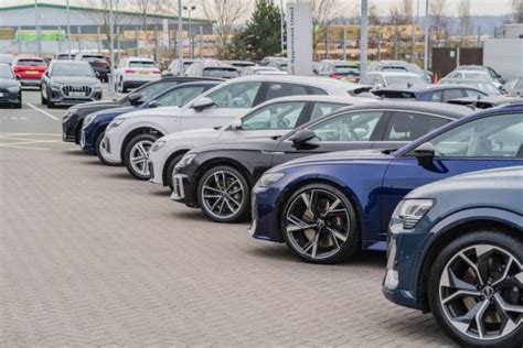 Un gruppo di auto Peugeot, Citroën e Opel parcheggiate davanti a una concessionaria moderna