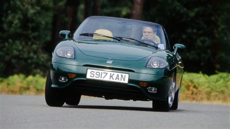 Fiat Barchetta parcheggiata al tramonto con la capote abbassata