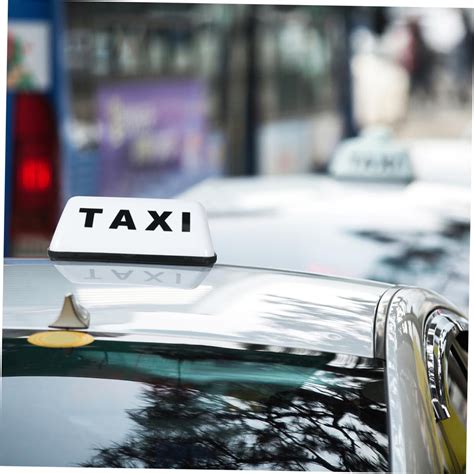 Veicolo taxi bianco con insegna luminosa sul tetto