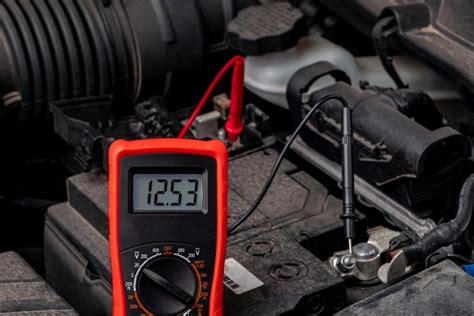 Primo piano di un voltmetro collegato ai terminali di una batteria moto