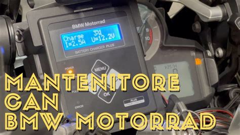 Moto BMW coperta in un garage durante l'inverno con un mantenitore di carica collegato