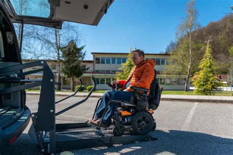 Persona su sedia a rotelle che entra in un veicolo adattato