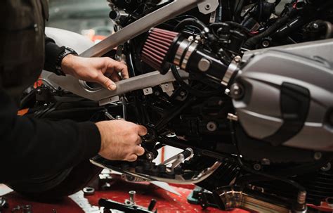 Tecnico che pulisce la superficie di una moto prima di applicare un adesivo