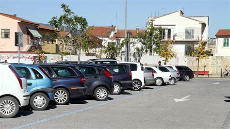 Varietà di auto in un grande parcheggio, alcune in vendita
