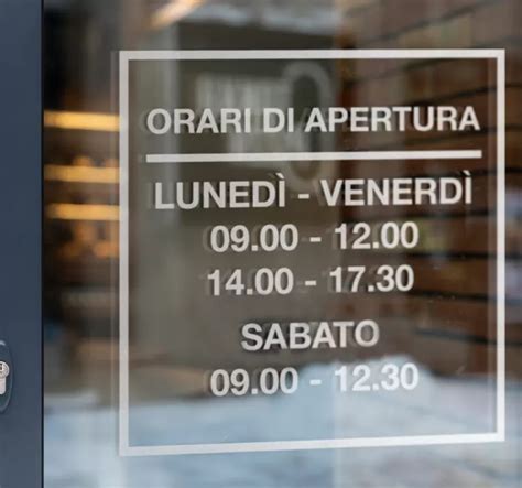 Vetrina di un'agenzia di pratiche auto con orari di apertura in evidenza