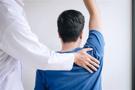 Fisioterapista che assiste un paziente con lesione alla spalla