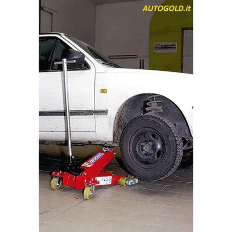 Meccanico che utilizza un cric idraulico professionale per sollevare un veicolo in officina