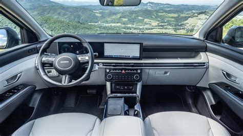 Interni di una Hyundai Tucson con cruscotto digitale e interni di una Nissan X-Trail con display centrale