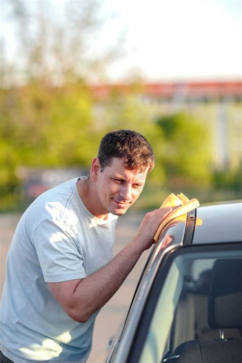 Persona che pulisce i bracci portabagagli di un'auto