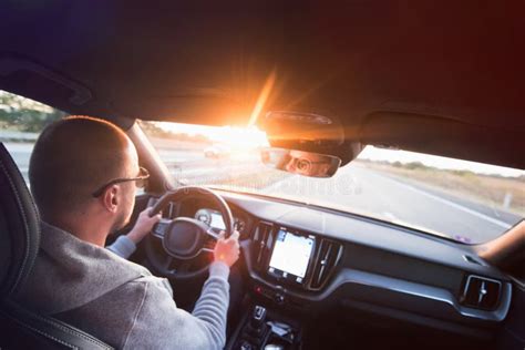 Un uomo con un'espressione furiosa al volante di un'auto nel traffico