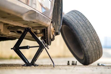 Schema che mostra il punto corretto di posizionamento del cric sotto il telaio di un SUV