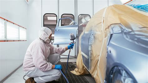 Carrozziere che prepara una superficie per la verniciatura