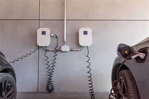 Immagine di una wallbox domestica installata in un garage, con un'auto elettrica collegata.