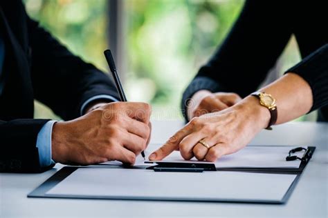 Uomo d'affari che firma documenti relativi all'auto in un'agenzia