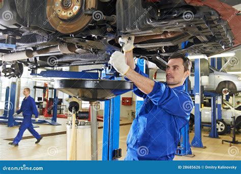 Meccanico al lavoro sulla sospensione di un'auto