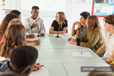Un'immagine di studenti che partecipano a un'attività di gruppo in classe di inglese, magari con un insegnante che facilita la conversazione