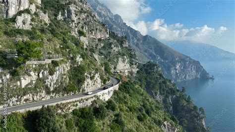 Panorama costiero della Sicilia con un'auto sportiva.