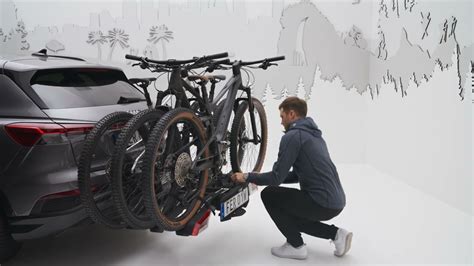 Diverse attrezzature sportive (biciclette, kayak, sci) caricate su un veicolo con portapacchi Thule