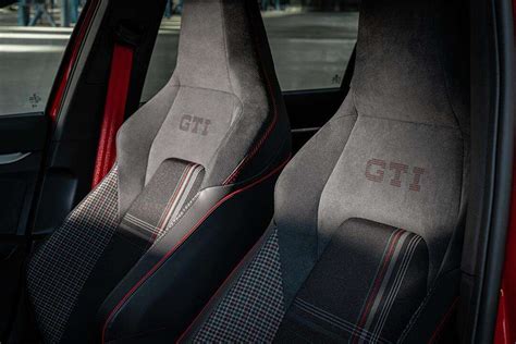 Interni della Nuova Golf GTI Edition 50 con sedili sportivi a scacchi e cinture rosse