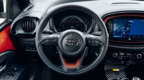 Interni della Toyota Aygo X con volante multifunzione e schermo infotainment