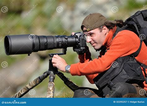 Fotografo con teleobiettivo che riprende un'auto da corsa in azione