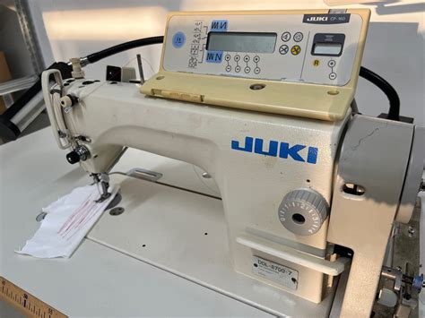 Dettaglio di una macchina da cucire Juki con interfaccia digitale