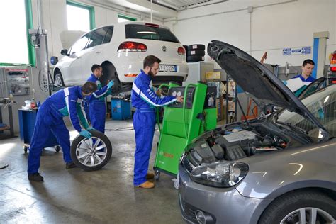 Tecnici qualificati che effettuano manutenzione su un'auto in officina