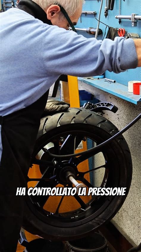 Meccanico che controlla la pressione di uno pneumatico