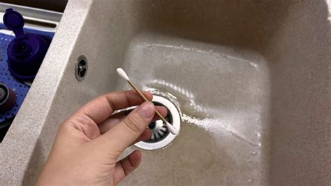 Un tecnico che esegue la manutenzione degli scarichi del tettuccio apribile con un piccolo tubo o uno strumento per rimuovere le ostruzioni