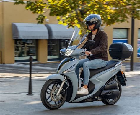 Una persona che guida uno scooter Kymco People GTi in ambiente urbano.