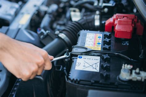 Persona che scollega la batteria dell'auto