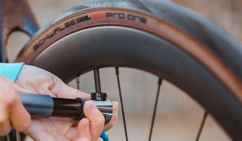 Ciclista che controlla la pressione degli pneumatici della bici con un manometro
