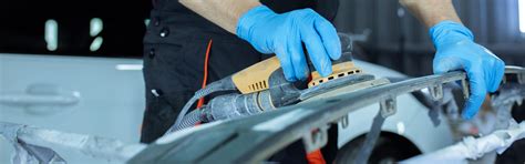 Tecnici al lavoro su una carrozzeria Dacia in un'officina moderna