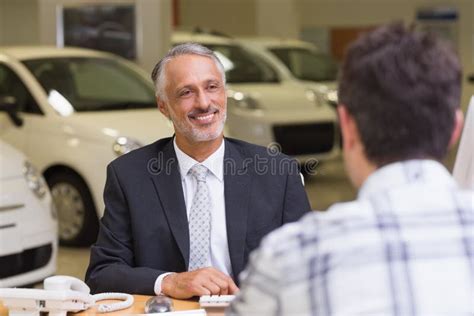 Interno di una concessionaria con personale che parla con un cliente