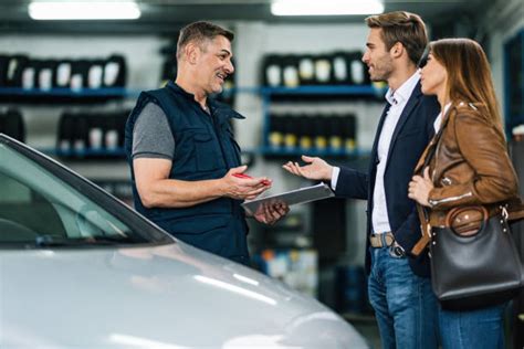 Illustrazione di un cliente che parla con un meccanico in un'officina auto